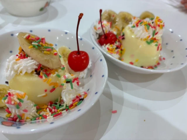 🍮はな組クッキング🍮

今回は、みんなで大好きなプリン作りに挑戦しました！

温めた牛乳にプリンの素を入れて、よ〜く混ぜたら、好きな形のカップにそっと注ぎます🥛💕
「どの形にしようかな？」と、自分で選ぶところからワクワク♪

冷蔵庫で冷やして、いよいよお楽しみの時間！
固まったプリンを見て、
「早く食べたい！」「固まってる！」
「いい匂い！」と、嬉しそうな声がたくさん聞こえてきました☺️

お皿にプッチンとすると……
クマさん、ハート、お花など、かわいい形のプリンが登場！

「ぷるぷる〜！」とお皿を動かしながら、目でもプリンを楽しんでいました👀✨

仕上げは、バナナ、さくらんぼ、チョコスプレー、生クリームを好きなようにトッピング♪

それぞれの個性が詰まった、とっても美味しそうなプリンが完成しました😋💕

#後閑あさひ保育園
#クッキング