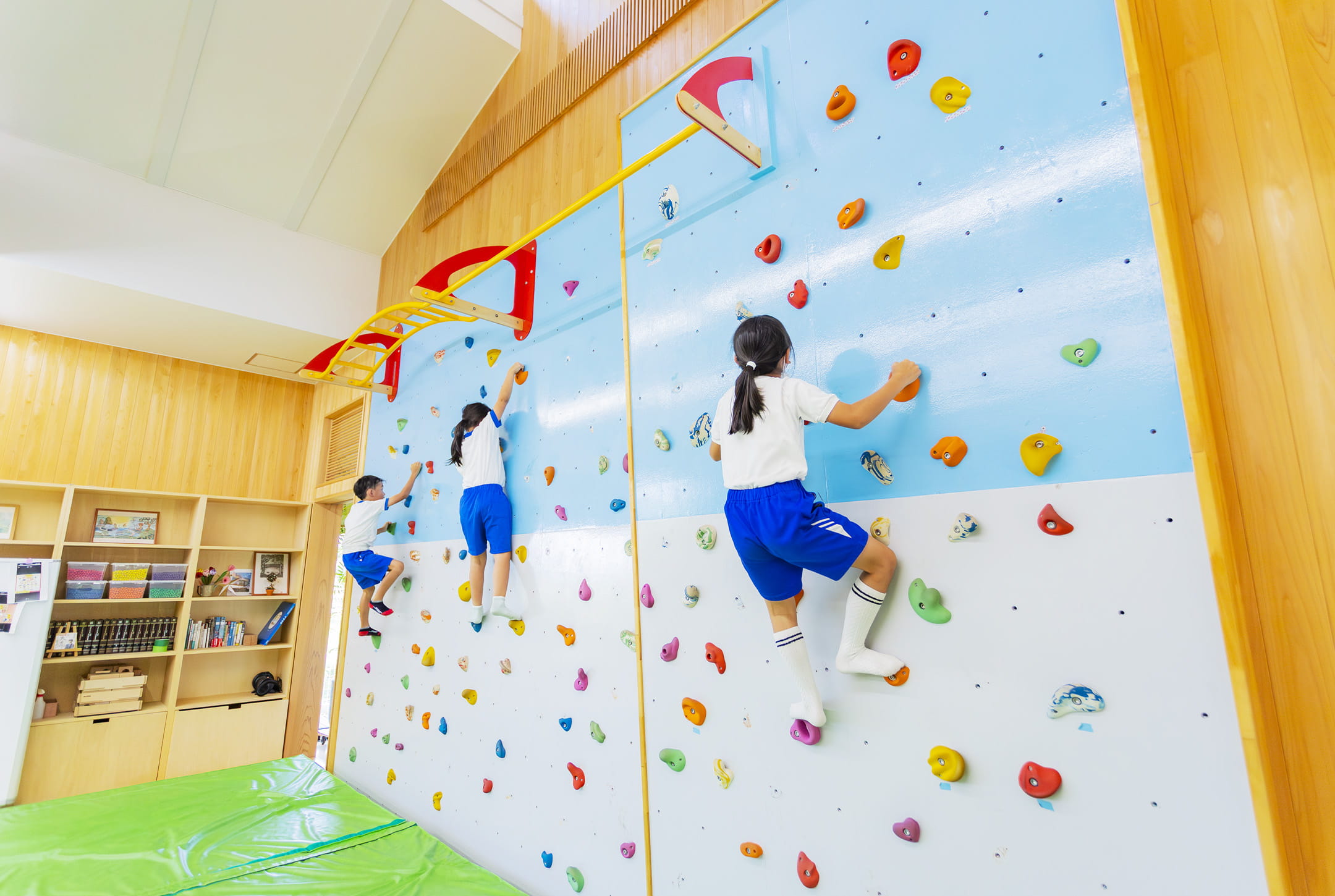 屋内の壁を使ったボルダリングで子どもたちが楽しそうに遊んでいる様子