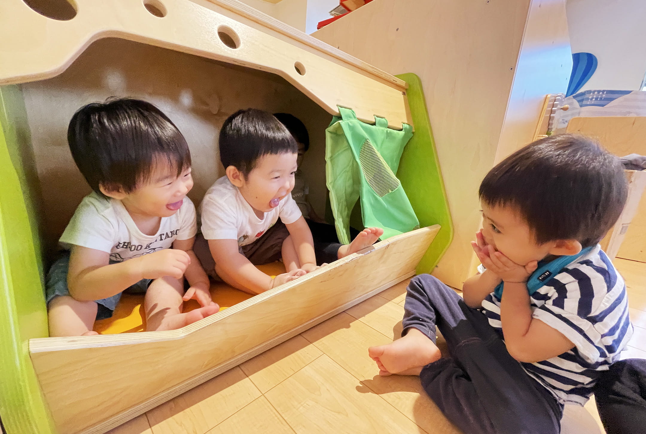 遊具の中で笑い合う子どもたちが楽しそうに遊んでいる様子